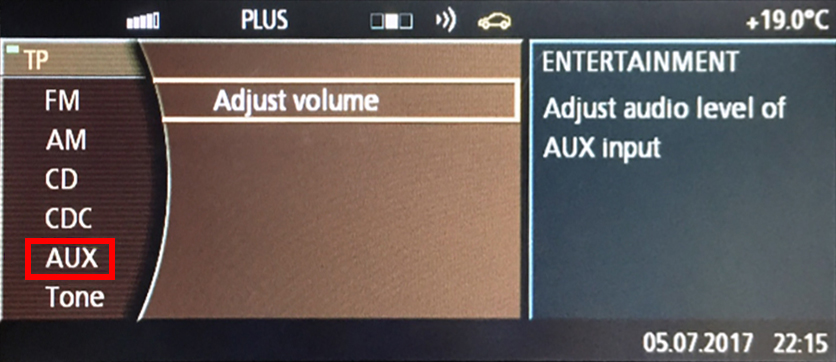 Adjusting the AUX audio level on a BMW's entertainment system screen.