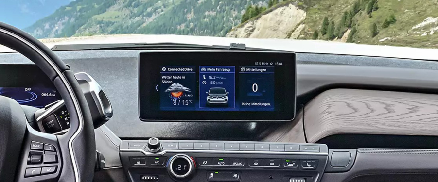 BMW i3 dashboard displaying weather & driving data in a mountain setting