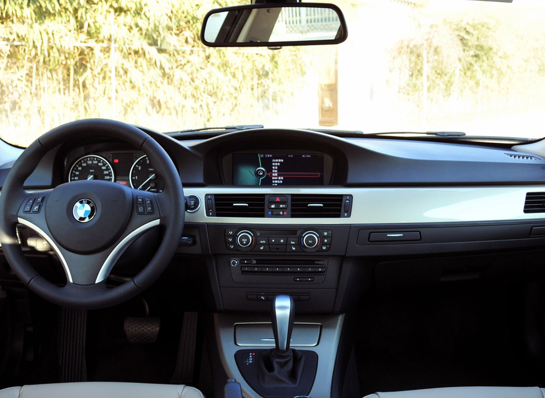 BMW dashboard interior featuring steering wheel, navigation screen, and gear shift